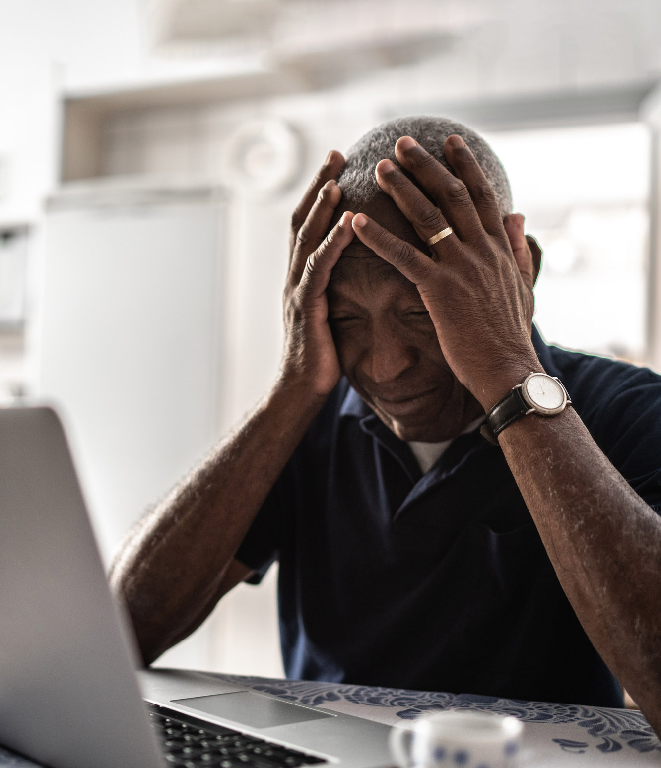 Worried senior man working at laptop