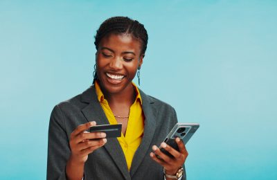 Studio, black woman and happy with phone for credit card, password and banking app for ecommerce. Mockup, business person and laugh with mobile for debit details, online shopping and blue background